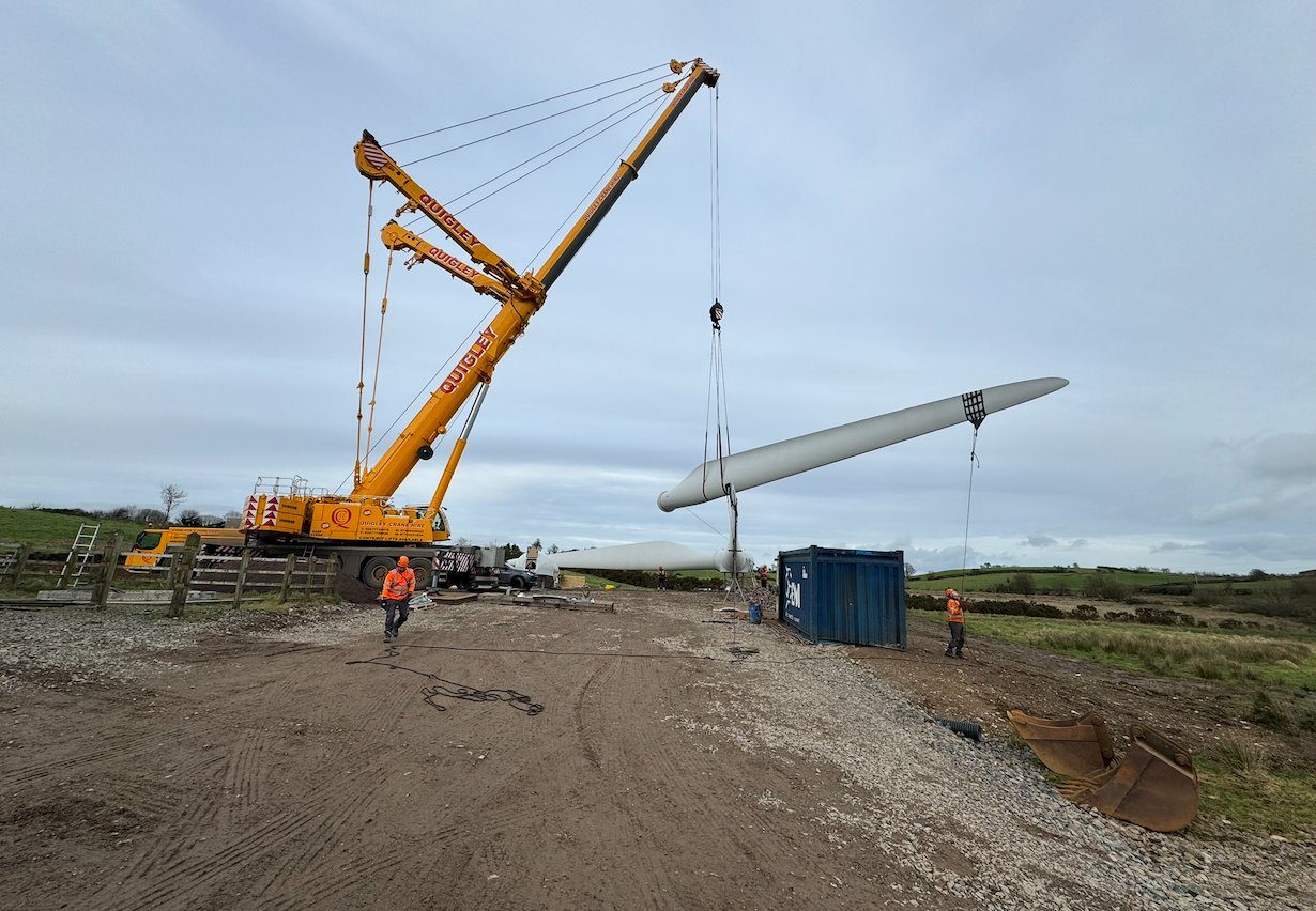 A mobile crane lifting a wind turbine blade during a major component job